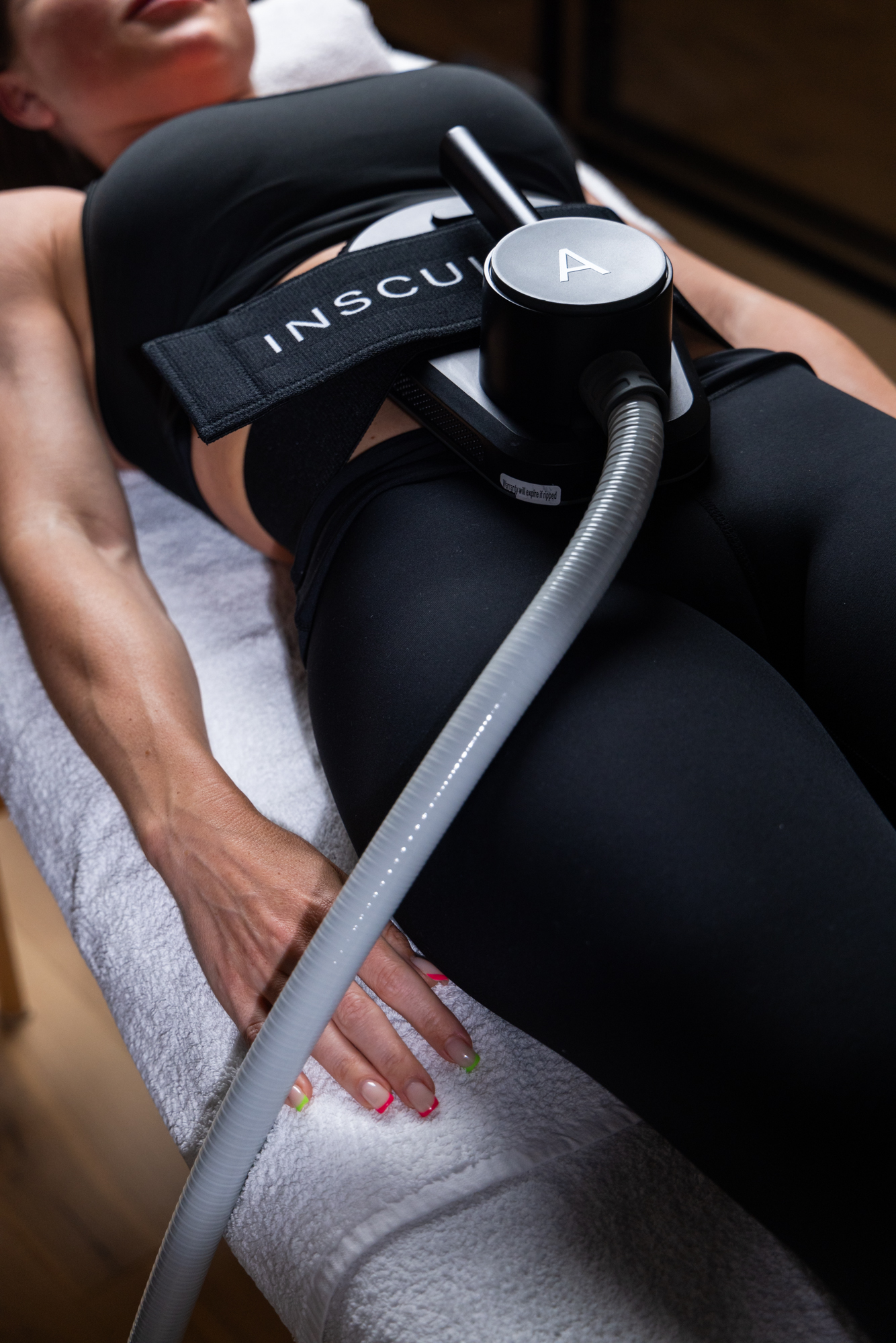 Insculpt-behandling, applikator festet på kroppen under en pågående økt